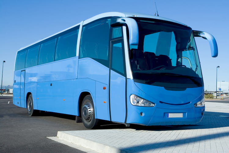 a blue charter bus waits to depart on a trip